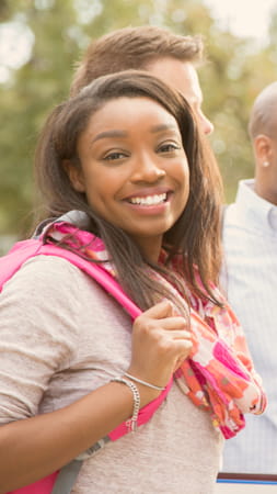 Woman holding a backpack and smiling