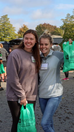 Two female students holding riverside bags at Trunk-or-Treat