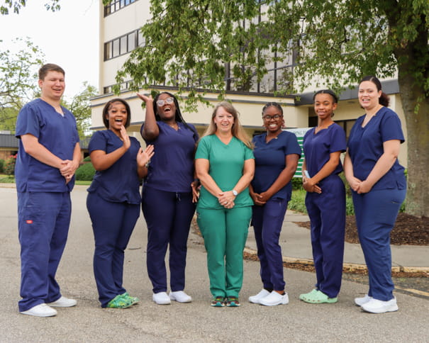 Group of CNA graduates in front of the administration building 