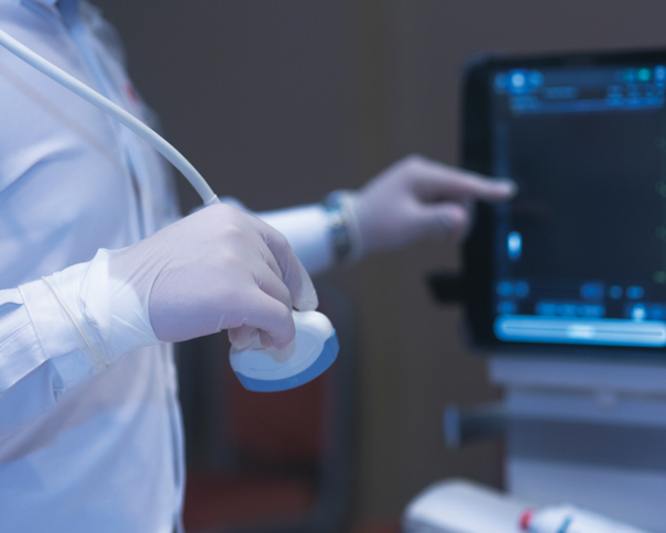 Gloved hands using sonography equipment