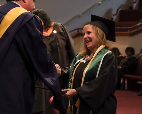 Female BSN graduate accepting her diploma at graduation