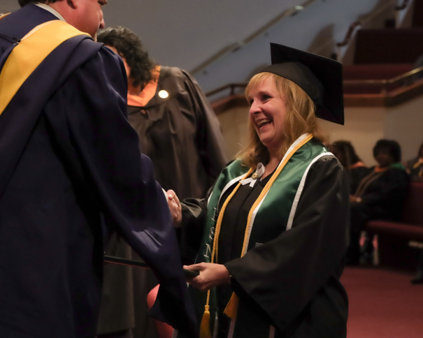 Female BSN graduate accepting her diploma at graduation