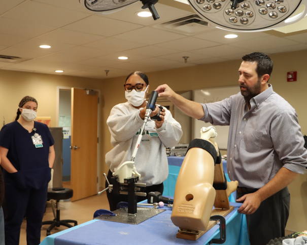 Female student practicing a hip replacement with an Instructor