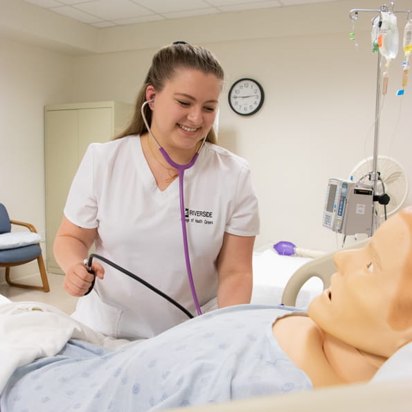 Nursing student practicing taking blood pressure.