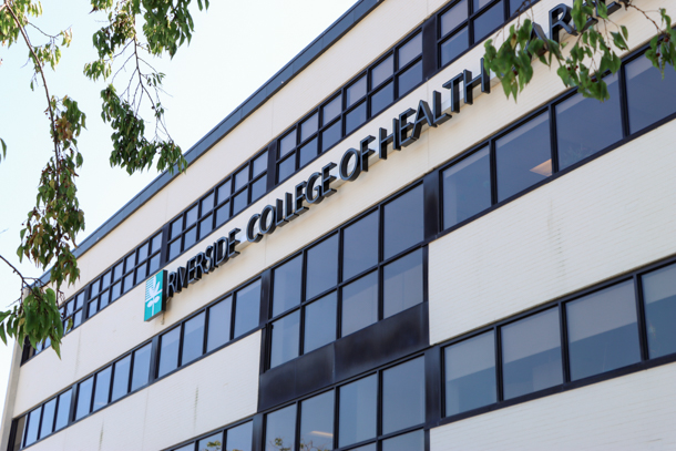 A large sign spelling out ‘Riverside College of Health Careers’ on the side of the admin building.