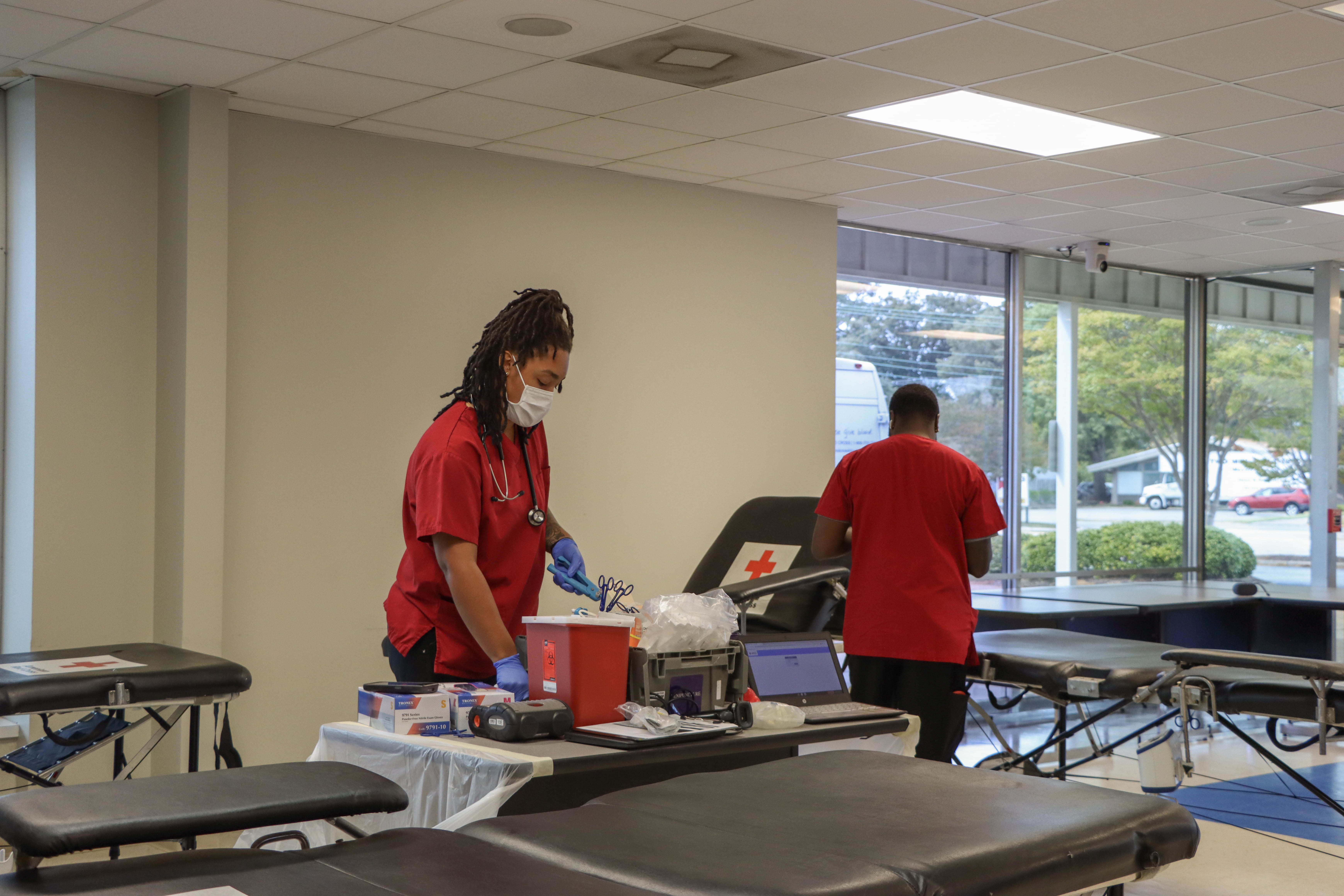 Two blood drive volunteers setting up for patients in an RCHC classroom.